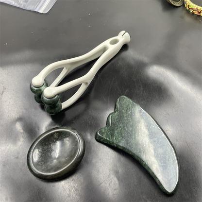 Set de masaje con piedras naturales: tabla raspadora, pinza para dedos y masajeador con forma de huevo.